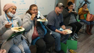 A group of people sitting down eating food.